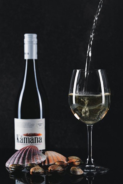 product photography of a bottle of wine and a glass bieng poured